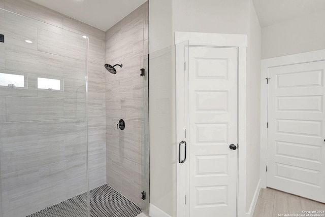 full bathroom with a stall shower and baseboards