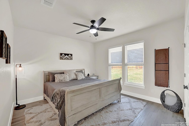 bedroom featuring light wood finished floors, visible vents, and baseboards