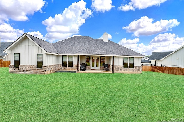 rear view of house with fence, board and batten siding, and brick siding