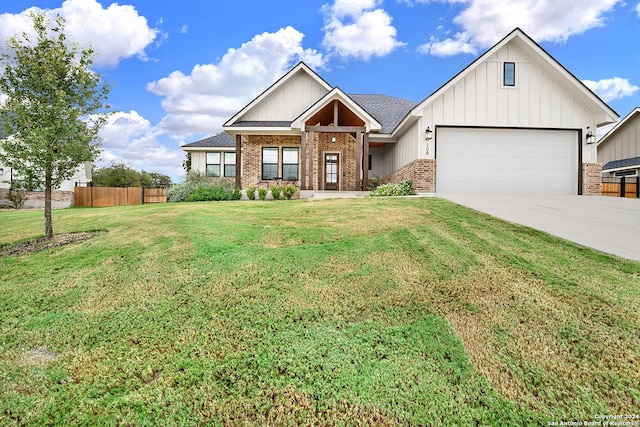 view of front of house with brick siding, fence, driveway, and a front lawn