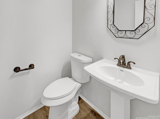 bathroom with toilet, wood-type flooring, and sink