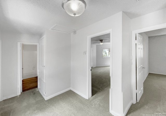 carpeted spare room with a textured ceiling and ceiling fan