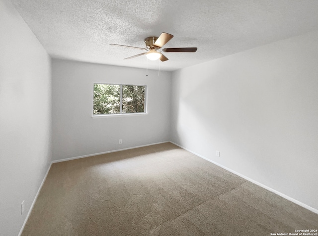 empty room with carpet flooring, a textured ceiling, and ceiling fan