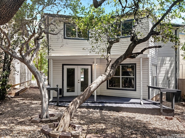 rear view of house featuring central air condition unit, a wooden deck, and french doors