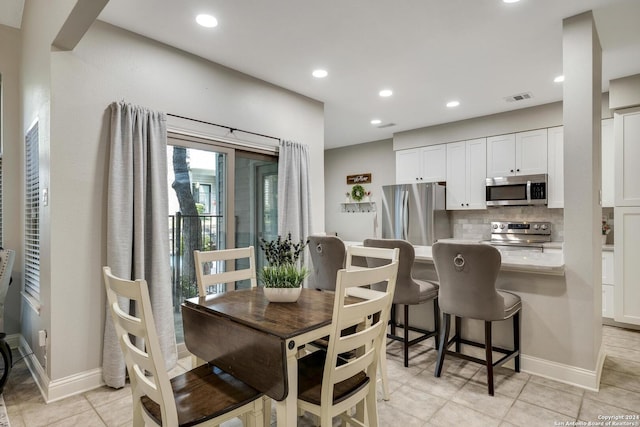 dining space featuring light tile patterned flooring, recessed lighting, visible vents, and baseboards