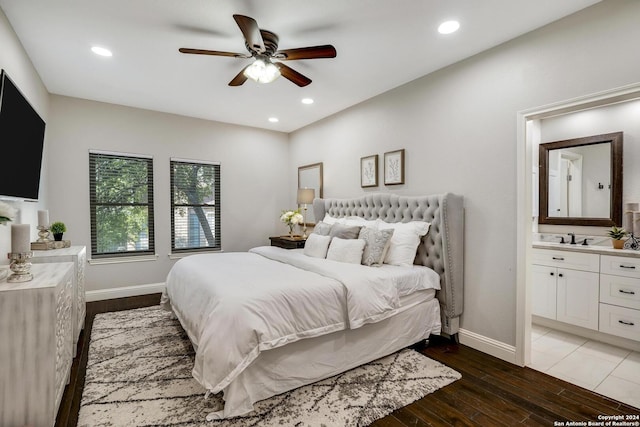 bedroom with recessed lighting, ensuite bathroom, baseboards, and wood finished floors