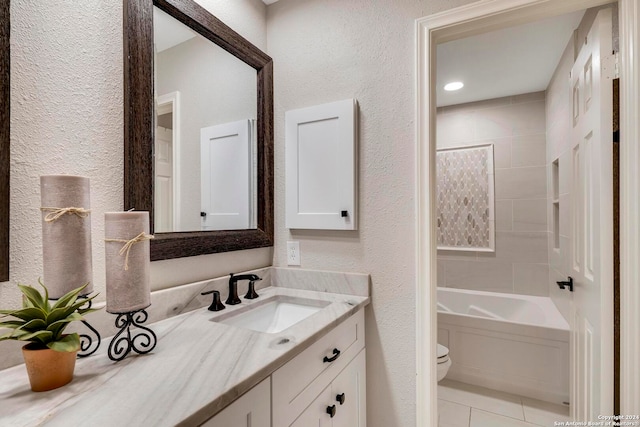 full bathroom featuring tiled shower / bath, vanity, toilet, and tile patterned flooring