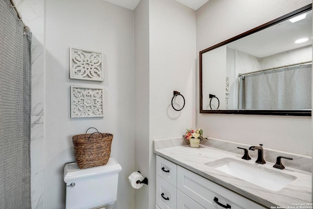 bathroom featuring walk in shower, toilet, and vanity