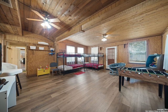 game room with ceiling fan, a wealth of natural light, wooden walls, and hardwood / wood-style floors