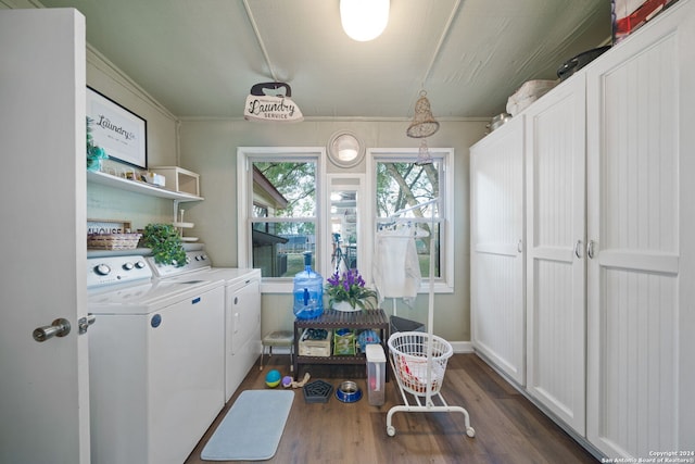 laundry room featuring cabinets, crown molding, dark wood-type flooring, and washing machine and clothes dryer