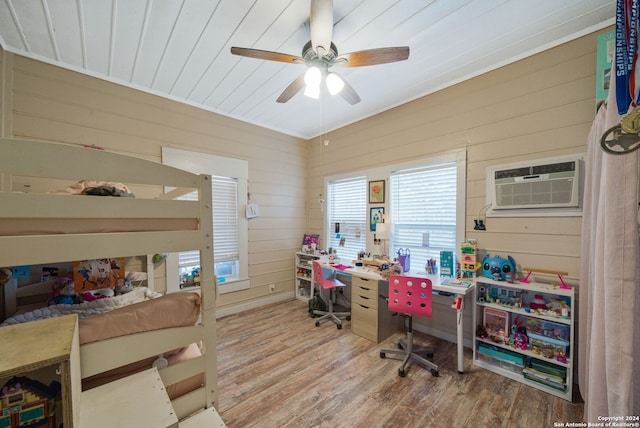 home office with hardwood / wood-style floors, ceiling fan, a wall unit AC, and wood walls