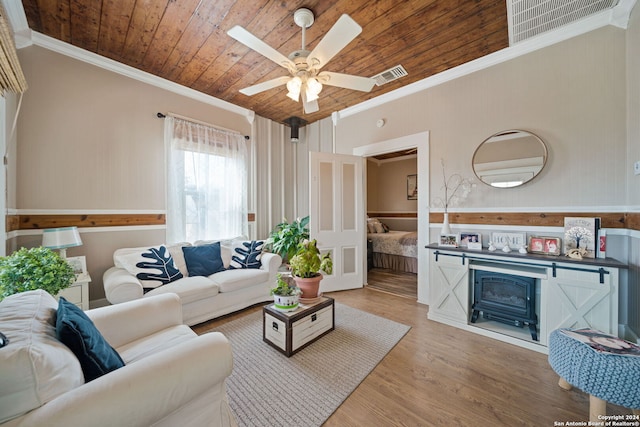 living room featuring a fireplace, hardwood / wood-style floors, ceiling fan, wooden ceiling, and ornamental molding