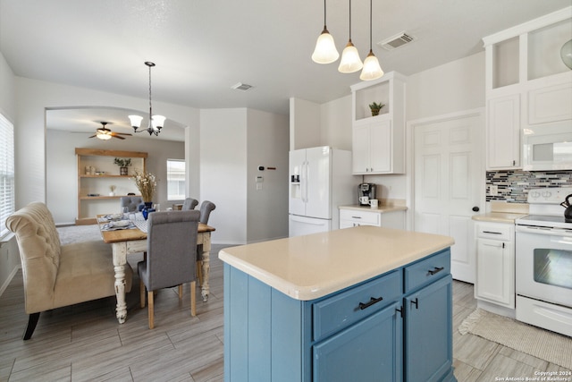 kitchen with blue cabinetry, white appliances, hanging light fixtures, and tasteful backsplash