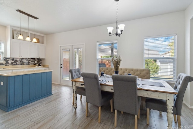 dining area featuring wood finish floors, baseboards, and an inviting chandelier