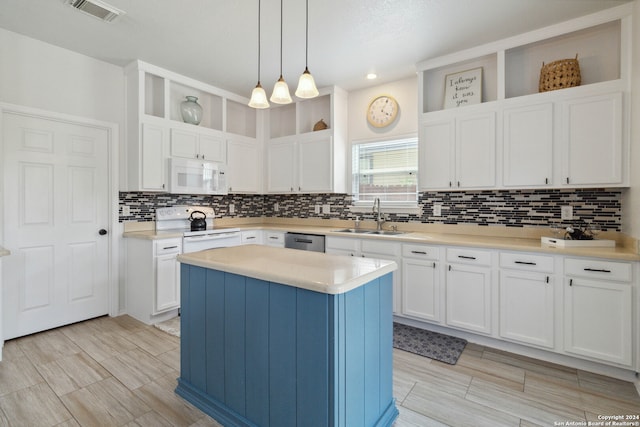 kitchen with white cabinetry, white appliances, tasteful backsplash, a kitchen island, and sink