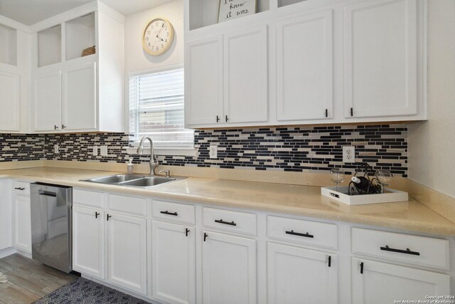 kitchen featuring white cabinetry, backsplash, a kitchen island, sink, and stainless steel dishwasher