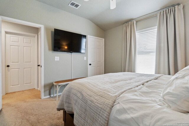 carpeted bedroom featuring lofted ceiling, ceiling fan, and a crib