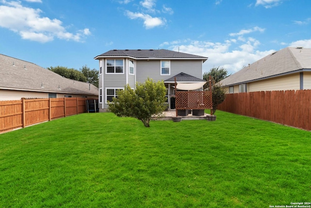 back of house with a lawn and a patio