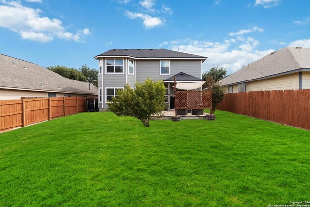 rear view of property featuring a lawn and a patio