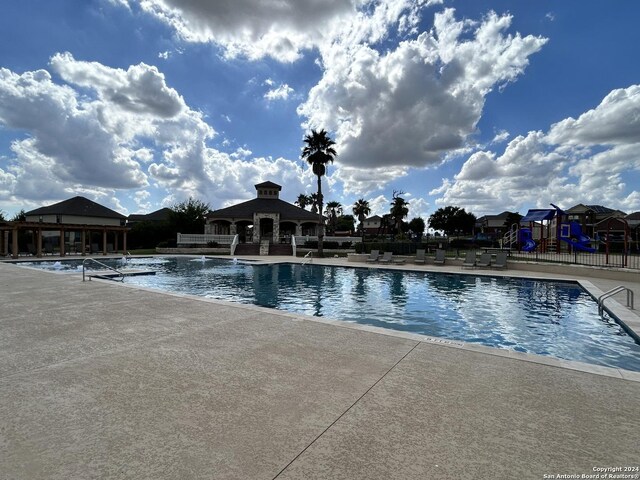 view of pool with a gazebo and a playground