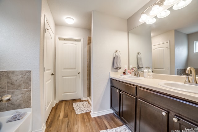 bathroom with vanity, wood-type flooring, and plus walk in shower