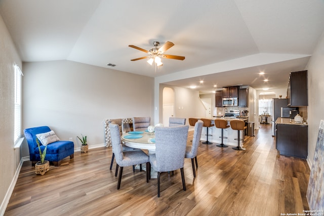 dining room featuring vaulted ceiling, wood-type flooring, and ceiling fan