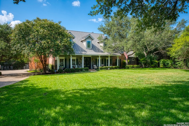 cape cod home featuring a front yard