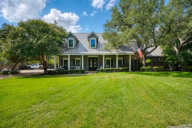 cape cod house featuring a front lawn and covered porch