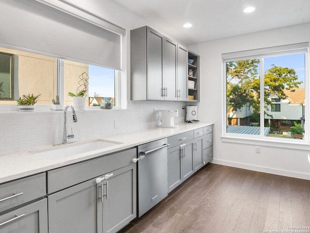 kitchen featuring a wealth of natural light, decorative backsplash, dark hardwood / wood-style floors, and stainless steel dishwasher