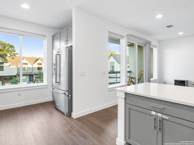 kitchen with high end refrigerator, plenty of natural light, and dark hardwood / wood-style flooring