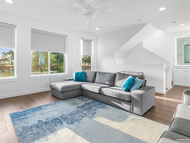 living room with dark wood-type flooring, a healthy amount of sunlight, and ceiling fan