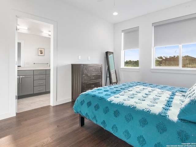 bedroom with ensuite bathroom and dark hardwood / wood-style floors