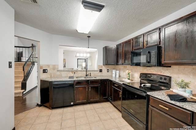 kitchen featuring black appliances, light stone counters, sink, and light hardwood / wood-style flooring