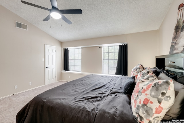 carpeted bedroom with lofted ceiling, ceiling fan, and a textured ceiling