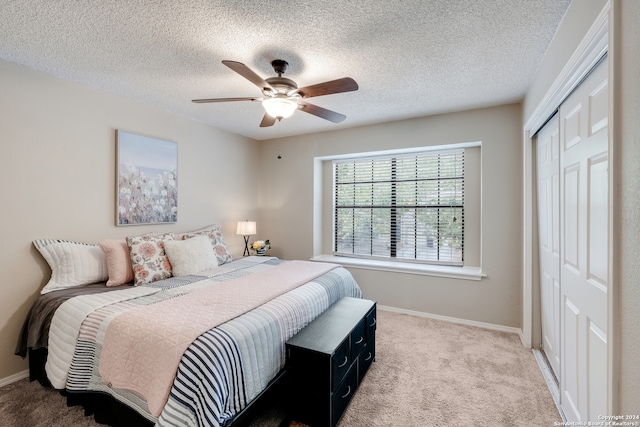 carpeted bedroom featuring a textured ceiling, ceiling fan, and a closet