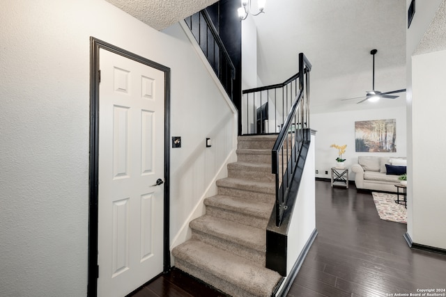 stairs featuring a textured ceiling, ceiling fan, and hardwood / wood-style floors