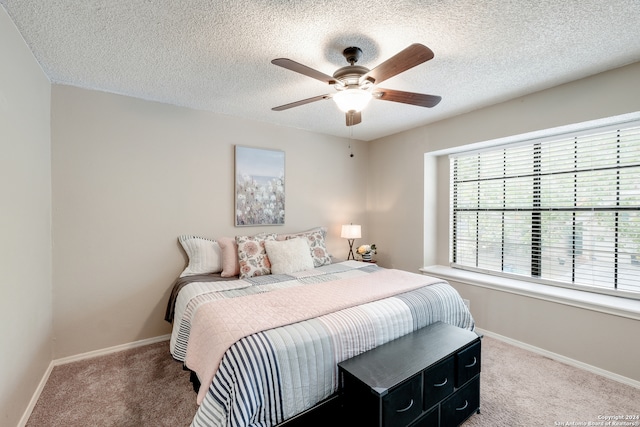 carpeted bedroom with a textured ceiling and ceiling fan