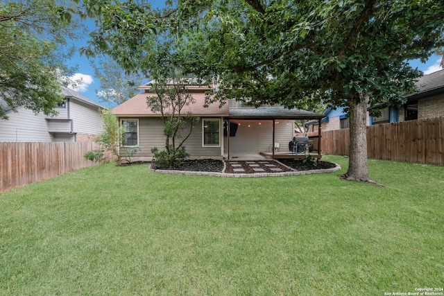 rear view of property featuring a yard and a patio