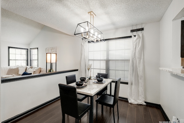 dining room with vaulted ceiling, dark hardwood / wood-style flooring, a chandelier, and a textured ceiling