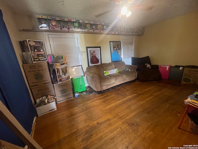 living room with ceiling fan, hardwood / wood-style flooring, and a textured ceiling