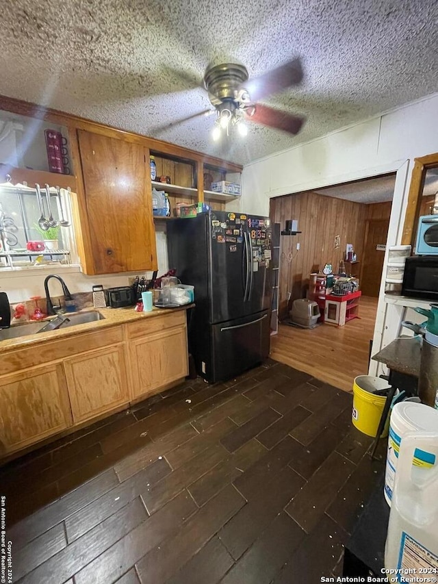 kitchen featuring a textured ceiling, black appliances, dark hardwood / wood-style flooring, sink, and ceiling fan