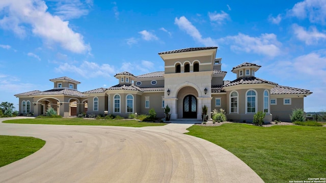 mediterranean / spanish-style house with a front lawn