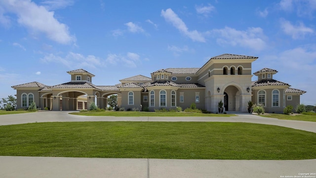 view of front of home featuring concrete driveway, a front yard, a tiled roof, and stucco siding