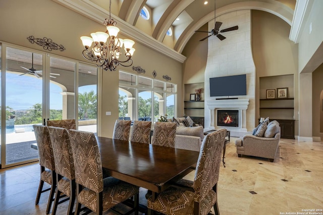 dining space with high vaulted ceiling, built in shelves, a fireplace, and a wealth of natural light