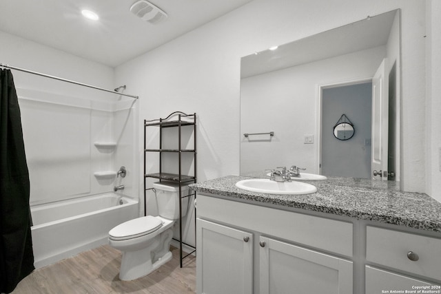 full bathroom featuring vanity, toilet, wood-type flooring, and shower / bath combo