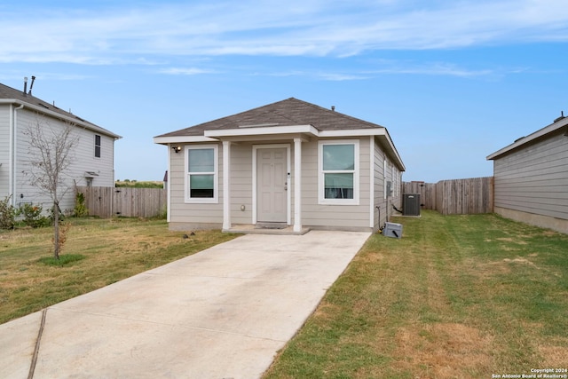 bungalow-style home featuring cooling unit, a front yard, and a patio area