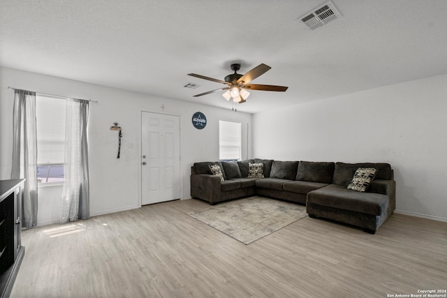 living room featuring light wood-type flooring and ceiling fan