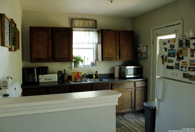 kitchen with dark wood-type flooring, dark brown cabinets, sink, and white refrigerator