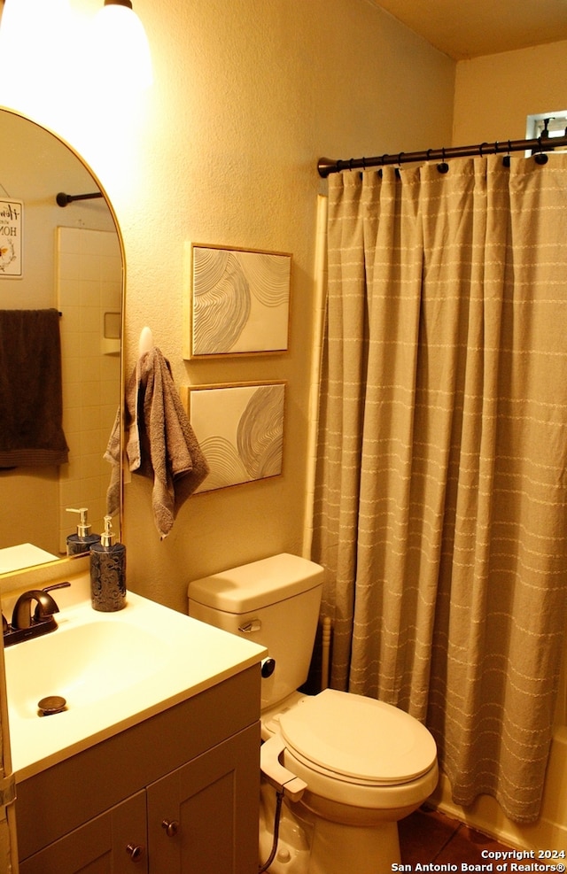 bathroom with toilet, vanity, and tile patterned floors