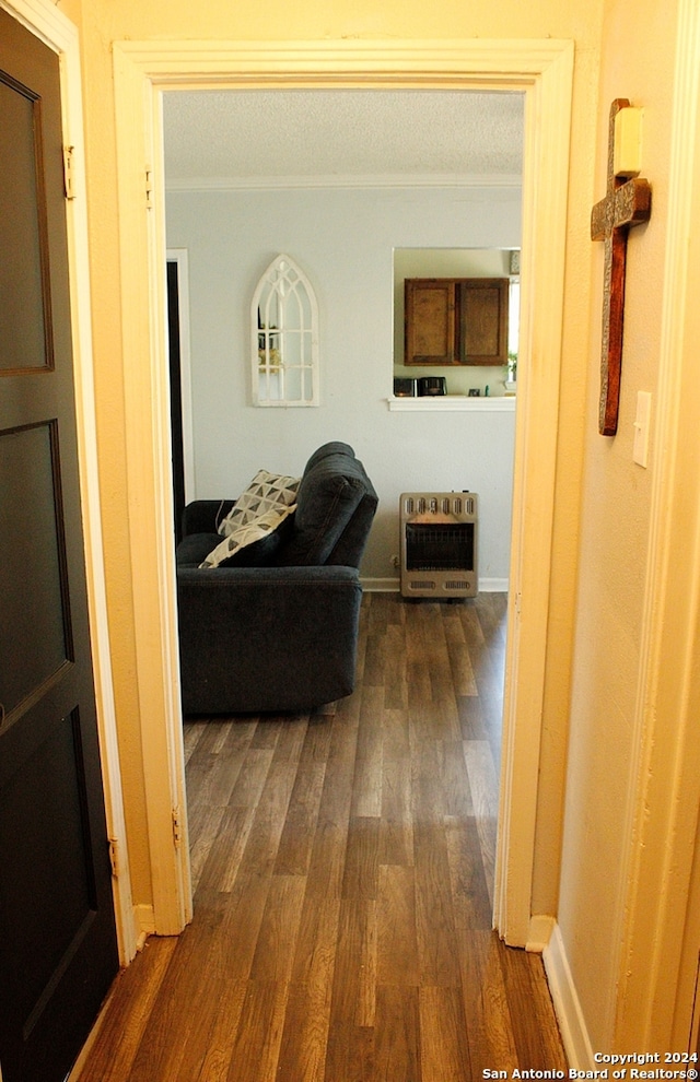 corridor featuring crown molding, heating unit, and dark hardwood / wood-style floors